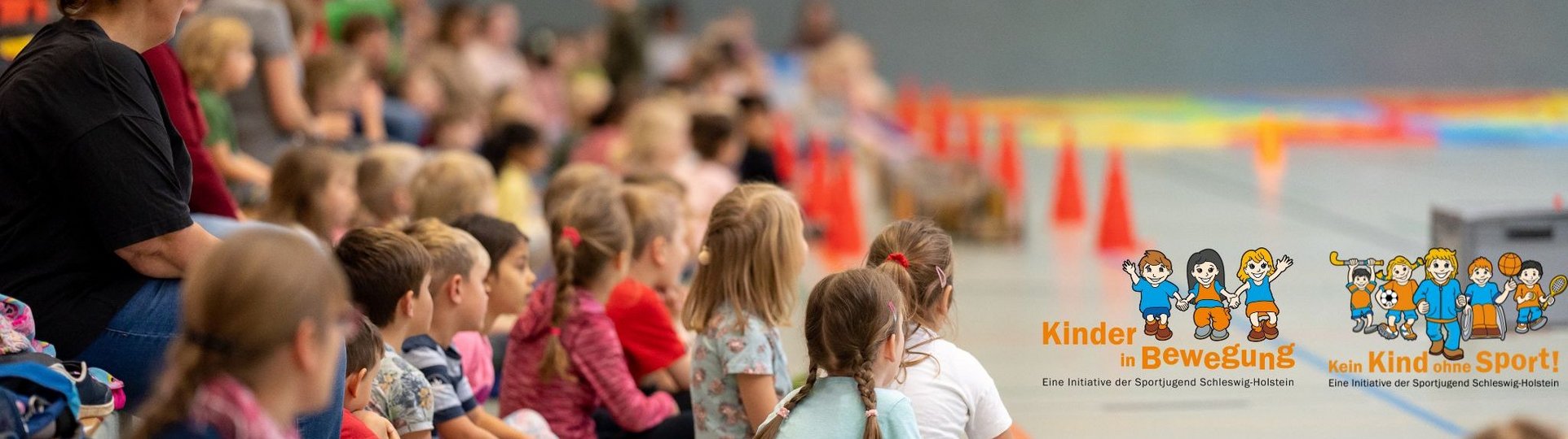 Kinder sitzen in der Turnhalle
