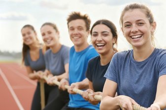 Fünf junge Menschen ziehen an einem Tau